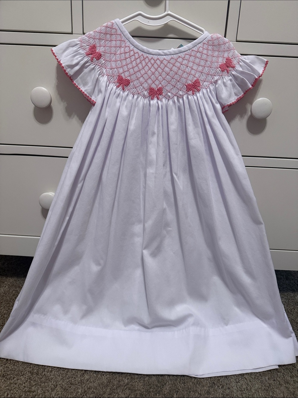 The Smocked Flamingo white seersucker with pink bow detail dress